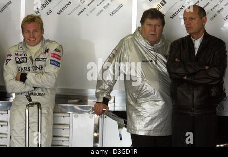 (Dpa) - finnischer Formel-1-Rennfahrer Kimi Raeikkoenen (L, Team McLaren-Mercedes) lächelt, steht er neben Mercedes Motorsport Direktor Norbert Haug (C) und McLaren-Mercedes-Teamchef Ron Dennis in Suzuka International Racing Course in Suzuka, Japan, 8. Oktober 2004. Wegen einen herannahenden Taifun könnte Rennen am Samstag abgesagt werden. Der Grand Prix von Japan stattfinden soll Stockfoto