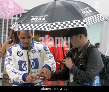 (Dpa) - kolumbianische Formel-1-Fahrer Montoya (Team BMW-Williams) schreibt ein Autogramm für ein Fan im Fahrerlager in Suzuka International Racing Course in Suzuka, Japan, 8. Oktober 2004. Wegen einen herannahenden Taifun könnte Rennen am Samstag und eventuell sogar am Sonntag abgesagt werden. Der Grand Prix von Japan wird voraussichtlich am Sonntag, 10. Oktober 2004 stattfinden. Stockfoto