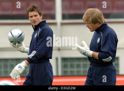 (Dpa-Dateien) - überqueren deutsche Nationalmannschaft Torhüter Jens Lehmann (l) und Oliver Kahn das Spielfeld während einer Trainingseinheit in Bukarest, Rumänien, 27. April 2004. Der Kampf um die besten Torwart vor Ort auf die deutsche Nationalmannschaft ist am 9. Oktober 2004 vor Deutschlands geplante internationale Freundschaftsspiel gegen den Iran in Teheran wieder belebt worden. Kahn und Lehmann haben gekämpft Stockfoto