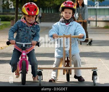 (Dpa) - Jule (R) und Sophie fahren auf einer Pedo-Bikes "Air Walk Dreirad (R) und eine Puki laufende Rad mit Bremse am Rhein in Köln, Deutschland, 15. September 2004. Die beiden Räder für Kinder sind nur zwei der vielen Neuheiten, die Sie auf dem Fahrradmarkt für Kinder heutzutage. Sie wurden zuerst auf der Fahrrad Handel Messe IFMA Cologne 2004 präsentiert. Stockfoto