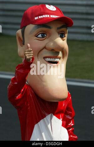 (Dpa) - ein Fan trägt eine Maske mit Schumachers Gesicht gibt die Daumen-hoch-Zeichen vor der chinesischen Formel Eins Grand Prix auf dem neuen Shanghai International Circuit in Shanghai, China, 26. September 2004. Stockfoto