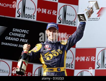 (Dpa) - britische Formel 1-Fahrer Jenson Button (BAR-Honda Team) wirft den Cup nach einem zweiten Platz in der chinesischen Grand Prix auf dem neuen Shanghai International Circuit in Shanghai, China, 26. September 2004. Brasilianische Fahrer Rubens Barrichello (Team Ferrari) gewann das Rennen vor Button und Finnlands Kimi Raeikkoenen (Team McLaren-Mercedes). Stockfoto