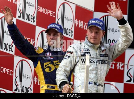 (Dpa) - britische Formel1-Fahrer Jenson Button (L, Team BAR-Honda) und Finnlands Kimi Raeikkoenen (Team McLaren-Mercedes) Welle nach Beendigung der zweiten und dritten bzw. in den chinesischen Grand Prix auf dem neuen Shanghai International Circuit in Shanghai, China, 26. September 2004. Das Rennen gewann brasilianische Fahrer Rubens Barrichello (Team Ferrari). Stockfoto