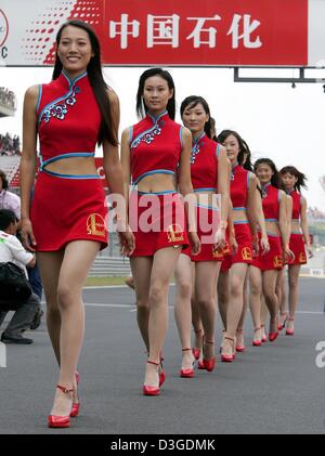 (Dpa) - chinesische Grid Girls gehen vorbei an Fans und Fotografen während einer Parade vor dem Start des chinesischen Grand Prix auf dem neuen Shanghai International Circuit in Shanghai, China, 26. September 2004. Stockfoto