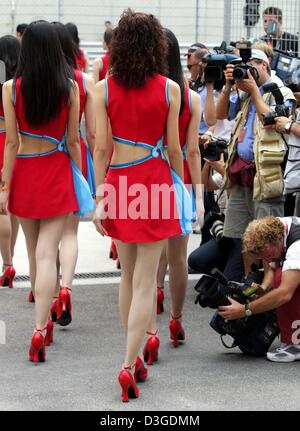 (Dpa) - chinesische Grid Girls gehen vorbei an Fans und Fotografen während einer Parade vor dem Start des chinesischen Grand Prix auf dem neuen Shanghai International Circuit in Shanghai, China, 26. September 2004. Stockfoto