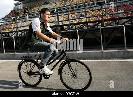 (Dpa) - australische Formel 1 pilot Mark Webber (Jaguar-Team) dauert eine Fahrt auf einem chinesischen Fahrrad um die Boxengasse auf die neue Formel 1 Rennstrecke in Shanghai, China, Donnerstag, 23. September 2004. Die chinesischen Grand Prix, das erste jemals Formel 1 Rennen auf chinesischem Boden, wird am Sonntag, 26. September 2004 stattfinden. Stockfoto