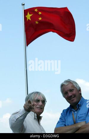 (Dpa) - Formel eine Supremo Bernie Ecclestone (L) und FIA-Renndirektor Charlie Whiting sprechen vor einem chinesischen nationalen Flagge am neuen Formel 1 Rennstrecke in Shanghai, China, Donnerstag, 23. September 2004. Die chinesischen Grand Prix, das erste jemals Formel 1 Rennen auf chinesischem Boden, wird am Sonntag, 26. September 2004 stattfinden. Stockfoto