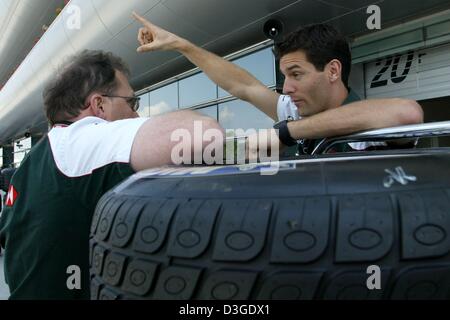 (Dpa) - australische Formel 1 pilot Mark Webber (R, Jaguar-Team) chats in der Boxengasse auf die neue Formel 1 Rennstrecke in Shanghai, China, Donnerstag, 23. September 2004. Die chinesischen Grand Prix, das erste jemals Formel 1 Rennen auf chinesischem Boden, wird am Sonntag, 26. September 2004 stattfinden. Stockfoto