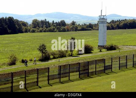 (Dpa) - ein Guard tower und der umstrukturierte Zaun kann man auf dem Gelände der ehemaligen Grenze Beobachtung Anlage "Point Alpha" in der Nähe von Rasdorf, Deutschland, 2. September 2004. Zu den ehemaligen Beobachtungspunkt konfrontiert jetzt eine Gedenkstätte, die US-Streitkräfte und die ostdeutsche Grenzpolizei einander seit vierzig Jahren auf sehr kurze Distanz zur Markierung einer der Hotspots des Eisernen Vorhangs während der kalten Wa Stockfoto