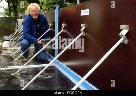 (Dpa) - Reinhard Vogt, Leiter des Referats Flood Schutz Köln, baut eine neue Hochwasserschutzmauer aus norwegischen Firma AquaFence AS an den Ufern des Rheins in Köln, Deutschland, 24. August 2004. Es dauert 10 Personen ca. 1 Stunde zum Einrichten einer 100 Meter langen Wand. Die Wand hat eine lange Lebensdauer und kann wiederverwendet werden. Seiner tatsächlichen Wirksamkeit wird jedoch nicht bis zum bekannt werden der Stockfoto