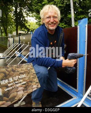 (Dpa) - Reinhard Vogt, Leiter des Referats Flood Schutz Köln, baut eine neue Hochwasserschutzmauer aus norwegischen Firma AquaFence AS an den Ufern des Rheins in Köln, Deutschland, 24. August 2004. Es dauert 10 Personen ca. 1 Stunde zum Einrichten einer 100 Meter langen Wand. Die Wand hat eine lange Lebensdauer und kann wiederverwendet werden. Seiner tatsächlichen Wirksamkeit wird jedoch nicht bis zum bekannt werden der Stockfoto