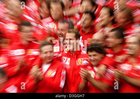 (Dpa) - deutsche Ferrari Formel1-Fahrer Michael Schumacher (C) mit seinem Team nach der belgischen Formel Eins Grand Prix in Spa, 29. August 2004 feiert. Schumacher wurde Zweiter im Grand Prix, Clinchen eine noch nie dagewesene siebten WM Titel trotz nicht gerade zum zweiten Mal in 14 Rennen in dieser Saison gewinnen. Stockfoto