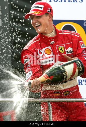 (Dpa) - deutsche Ferrari Formel 1-Pilot Michael Schumacher spritzt Champagner beim Feiern auf dem Podium nach der belgischen Formel Eins Grand Prix in Spa, 29. August 2004. Michael Schumacher wurde Zweiter im Grand Prix, Clinchen eine noch nie dagewesene siebten WM Titel trotz nicht gerade zum zweiten Mal in 14 Rennen in dieser Saison gewinnen. Stockfoto