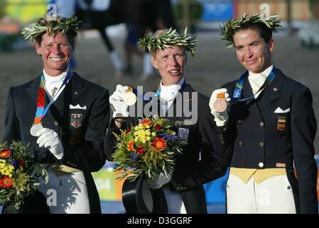 (Dpa) - Anky van Grunsven (C) aus den Niederlanden lächelt, als sie ihre Goldmedaille nach dem Gewinn der Olympischen individuelle Dressur Grand Prix in Markopoulo Olympic Equestrian Center in Athen, Griechenland, 25. August 2004 zeigt. Zu ihrer linken ist Silbermedaillengewinner Ulla Salzgeber aus Deutschland und auf ihr Recht Bronzemedaillengewinner Beatriz Ferrer-Salat aus Spanien. Stockfoto