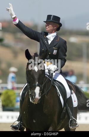 (Dpa) - "Wellenlinien" Anky van Grunsven aus den Niederlanden auf ihrem Berg Salinero der Menge nach der gemischten einzelnen Dressur Grand Prix Special am Markopoulo Olympic Equestrian Centre während der 2004 Olympischen Spiele in Athen, Montag, 23. August 2004. Stockfoto