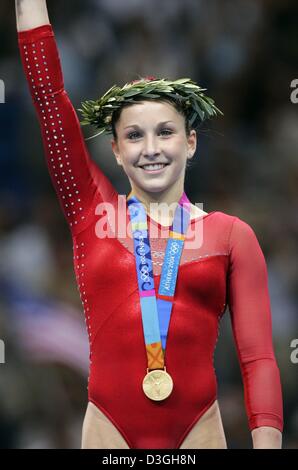 (Dpa) - US-Turnerin Carly Patterson Wellen den Hand und lächelt nach dem Gewinn der Goldmedaille in der Frauen individuelle Allround-Finale in Gymnastik von den Olympischen Spielen 2004 in der Ellinikon Indoor Arena in Athen, Griechenland, 19. August 2004. Patterson gewann die Goldmedaille. Stockfoto