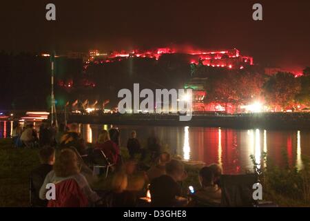 (Dpa) - rote Leuchten auf einer Burg kurz bevor Feuerwerk über dem Fluss Rhein für die abschließende Zeremonie des Festivals "Rhein in Flammen" abgelassen werden (Rhein in Flammen) in Koblenz, Deutschland, 14. August 2004. Die Veranstaltung findet jedes Jahr statt. Stockfoto