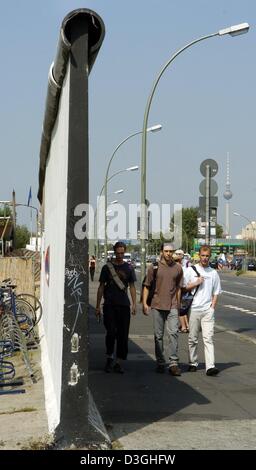 (Dpa) - Touristen gehen vorbei an den Überresten der Berliner Mauer, 12. August 2004. Die so genannte "East-Side-Gallery" steht unter Denkmalschutz und bildet den am längsten noch bestehenden Teil der ehemaligen Trennlinie, dass getrennte Ost- und West-Berlin. Stockfoto