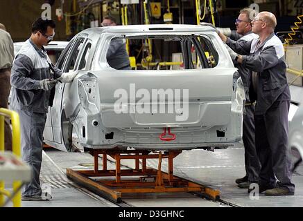 (Dpa) - Arbeiter mit einer Karosserie des Opel Astra Caravan im Opel-Werk Bochum, Deutschland, 16. August 2004. Opel plant 20 Astras pro Stunde in Zukunft produzieren. Die Produktion wird auf 400 Autos angehoben werden. Stockfoto