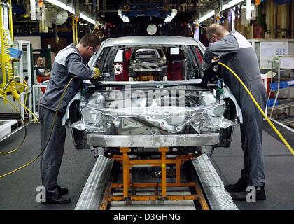 (Dpa) - Arbeiter mit einer Karosserie des Opel Astra Caravan im Opel-Werk Bochum, Deutschland, 16. August 2004. Opel plant 20 Astras pro Stunde in Zukunft produzieren. Die Produktion wird auf 400 Autos angehoben werden. Stockfoto