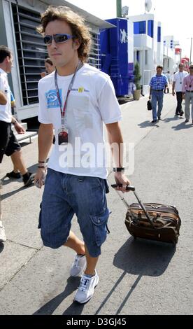 (Dpa) - spanische Formel 1 Piloten Fernando Alonso (Renault) führt durch das Fahrerlager an der Rennstrecke Hungaroring in Budapest, Ungarn, 12. August 2004. Formel 1 Grand Prix von Ungarn wird am Sonntag, 14. August im Gange sein. Alonso gewann letztes Jahr. Stockfoto