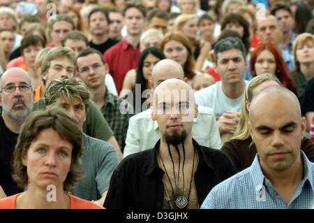 (Dpa) - Buddhisten meditieren, während der Eröffnungszeremonie ein buddhistisches Sommercamp in Immenhausen, Deutschland, Donnerstag, 29. Juli 2004. Mehrere tausend Buddhisten nehmen an der Einweihung des Sommerlagers die führt und berät Besucher in die Grundlagen der meditativen Praxis und buddhistischen Lehren. Stockfoto