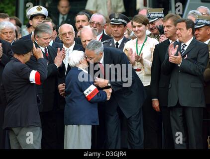 (Dpa) - German Chancellor Gerhard Schroeder (R) klatscht in die Hände wie US State Secretary Colin Powell (C) polnischen Veteranen der Gedenkstätte umfasst die Widerstandskämpfer und Tote im Warschauer Aufstand in Warschau, Polen, 1. August 2004 erinnert. Schroeder war unter den internationalen Gästen, die an den Feierlichkeiten anlässlich des 60. Jahrestages der teilgenommen haben Stockfoto