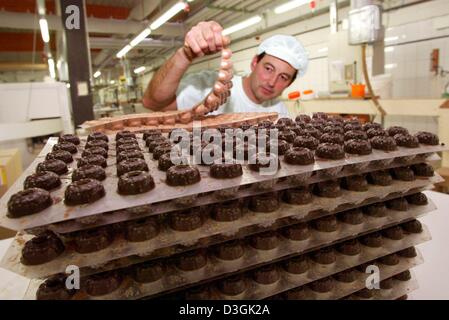 (Dpa-Dateien) - ist ein Mitarbeiter des deutschen Süßwarenhersteller Leysieffer bei der Herstellung von Pralinen in Osnabrück, 19. November 2003. Die internationale Erfolgsgeschichte der Süßwaren und Coffeeshop-Kette begann 1978. Von der Zentrale in Osnabrück gebaut Leysieffer ein Netzwerk, das jetzt auf die feine Süßigkeiten-Markt mit Filialen in der ganzen Eu Stockfoto