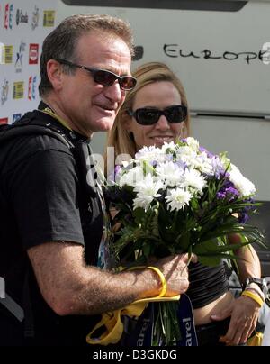 (Dpa) - US-Sängerin Sheryl Crow (R) hält die Blumen ihr Freund, US-Radsportler Lance Armstrong-Team US Postal, erhielt für die 15. Etappe des 91. Tour de France-Radrennen in Villard-de-Lans, Frankreich, 20. Juli 2004 zu gewinnen. Sie wird durch US-Schauspieler Robin Williams, ein Freund von Armstrong geholfen wird. Armstrong gewann die 180,5 km langen Etappe von Valreas, Villard-de-Lans nach outsp Stockfoto