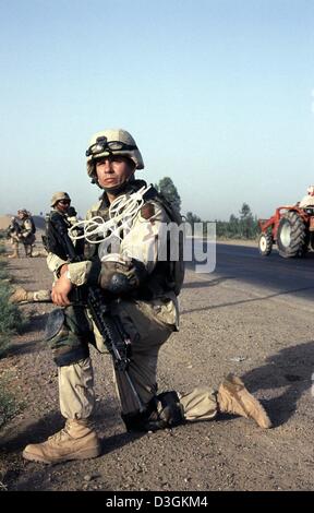 (Dpa) - US-Soldaten, ist das Tragen eines (vorne) Kunststoff Handschellen von der Firma C 1. Bataillon 26. Infanterie-Regiment sicher mit ihren 5,56 mm M16 A4 Angriff Gewehre ihre Kameraden während einer Prüfung von einem Straßenrand für IED, Improvised Explosive Device, südlich von Balad, der Irak, 1. Juni 2004. Stockfoto