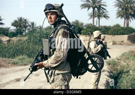 (Dpa) - eine US Soldat der Scout Platoon Task Force 1. Bataillon 77th Armor Regiment, ausgestattet mit einem Gewehr und einem Metalldetektor sucht nach versteckten Waffen außerhalb der Stadt von Albur Shakar, Irak, 30. Mai 2004. Stockfoto