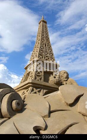 (Dpa) - hat einen Eiffelturm Sand Türme über den Strand in Travemünde, Deutschland, 5. Juli 2004. 75 so genannte Carver aus 13 Ländern arbeiten an ihre Skulpturen für den 3. deutschen Sandskulpturenfestival, Sand World, die unter dem Motto "Mythos von Olympia" in diesem Jahr sein wird. Das Festival mit der Wahrzeichen der Austragungsorte, die Olympischen Spiele der Neuzeit stattgefunden haben Stockfoto