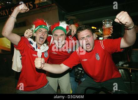 (Dpa) - englischer Fußball-Fans jubeln und feiern auf den Straßen von Lissabon, Portugal, 21. Juni 2004. England gewann seine letzten Fußball EM 2004 Gruppe B Spiel gegen Kroatien 4: 2 und qualifizierte sich für das Viertelfinale, während Kroatien außer Konkurrenz fallen gelassen. Stockfoto