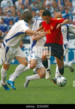 (Dpa) - Dribbling spanische Mittelfeldspieler Vicente (R) wird von griechischen Mittelfeldspieler Theodoros Zagorakis (C) und seinem Teamkollegen Georgios Seitaridis während der Fußball EM 2004-Gruppenspiel gegen Spanien und Griechenland im Bessa-Stadion in Porto, Portugal, 16. Juni 2004 angegriffen. Das Spiel endete mit einem 1: 1-Unentschieden. +++ KEINE HANDY-ANWENDUNGEN +++ Stockfoto