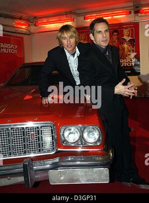 (Dpa) - US Schauspieler Owen Wilson und Ben Stiller (R) stellen auf der Motorhaube ihres Autos Film, eine eklatante roten Ford Gran Torino, bei der Premiere ihres Films "Starsky & Hutch" in München, 9. März 2004. Owen und Stiller spielen der Cop-Duo Ken Hutchinson und David Starsky in dem Remake der legendären 70er Jahre TV-Serie. Das rote Auto mit einem weißen Rallye-Streifen an den Seiten war das Markenzeichen Stockfoto