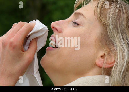 (Dpa-Datei) - das Bild vom 6. Mai 2005, zeigt eine junge Frau bläst ihre Nase mit einem Papiertaschentuch in Gescher, Deutschland.  Im Freien wird oft ein Aufwand für einen Allergiker. Pollen fliegen reizt die Schleimhäute und wilde niesende Angriffen provozieren kann. Stockfoto