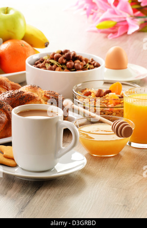 Frühstück mit Kaffee, Brot, Honig, Orangensaft, Müsli und Obst Stockfoto