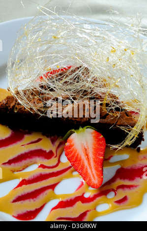 Reiche Schokoladenmousse Kuchen mit Baileys Sauce und gesponnenem Zucker in einem Shropshire-restaurant Stockfoto