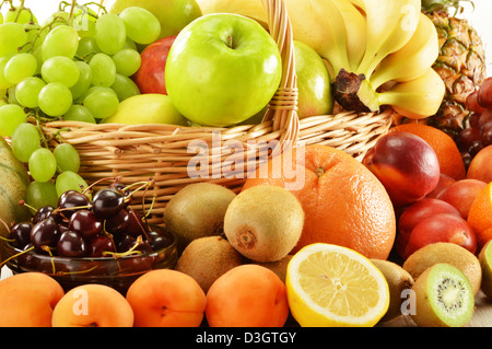 Komposition mit verschiedenen Früchten in Weidenkorb isoliert auf weiss Stockfoto