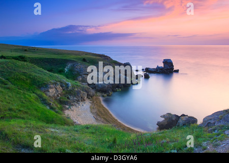 Erstaunliche Felsküste bei Sonnenuntergang mit der Insel Stockfoto