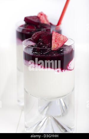 Zwei Gläser hausgemachte Joghurt Quark Dessert mit Heidelbeeren und Apfelscheiben auf hellem Hintergrund Stockfoto