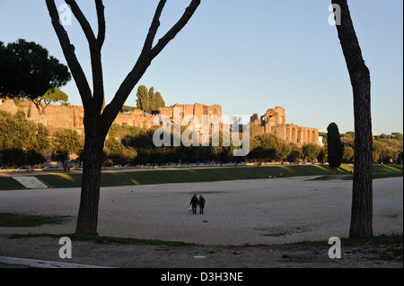 Bei Sonnenuntergang ein paar Spaziergang über das Gelände des Circus Maximus in Rom, Italien. Die Ruinen der Palatin-Hügel im Hintergrund Stockfoto