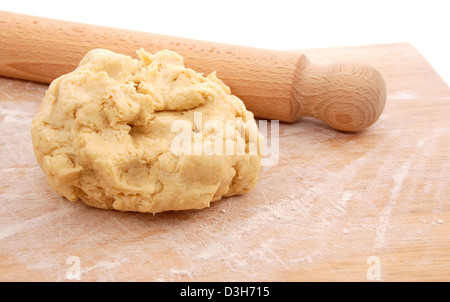 Hölzernen Nudelholz und eine frische Kugel aus Teig auf einem bemehlten Brett ausgerollt bereit Stockfoto