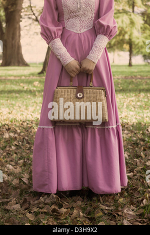 eine Frau mit einer Vintage Handtasche in den Wäldern im Herbst Stockfoto