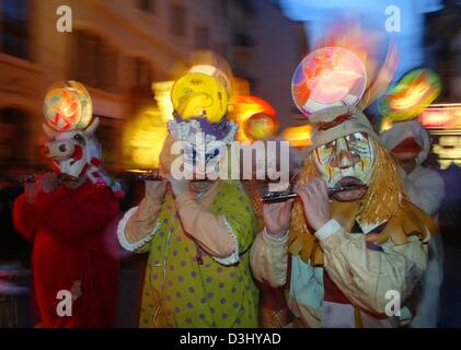 (Dpa) - Karneval Narren spielen Musik, wie sie zu eine Straße in der Innenstadt von Basel, Schweiz, 1. März 2004 Fuß. Die traditionelle "Morgenstraich" (Morgen-Witz) eröffnet die Karnevalssaison in Basel. Zu Beginn der besten drei Tage versammelten sich Hunderte von tausend Zuschauern, um die Parade der Trommler und Whistlers in Verkleidung zu sehen. Die Stadt Basel hat zu seinen Karneval Traditi eingehalten. Stockfoto