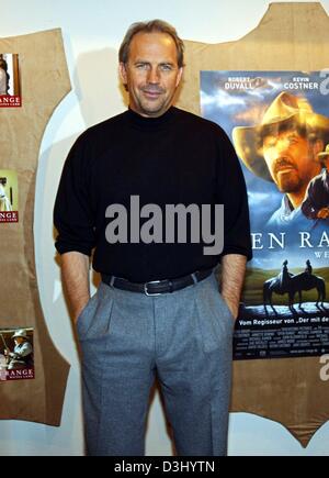 (Dpa) - US-Schauspieler und Regisseur Kevin Costner Lächeln als He Posen vor der ein Plakat wirbt für seinen neuesten film "Open Range" kurz vor der Premiere des Films Kostner in Hamburg, Germany, 23. Januar 2004. Der Film erscheint offiziell am 29. Januar 2004 in Deutschland. Stockfoto