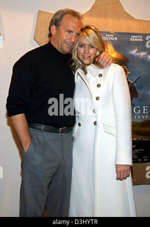 (Dpa) - US-Schauspieler und Regisseur Kevin Costner steht Arm in Arm mit seiner Verlobten Christine Baumgartner vor ein Plakat wirbt für seinen neuesten film "Open Range" kurz vor der Premiere des Films Kostner in Hamburg, Germany, 23. Januar 2004. Der Film erscheint offiziell am 29. Januar 2004 in Deutschland. 49-j hrige Kostner und 29-j hrige Baumgartner planen Stockfoto