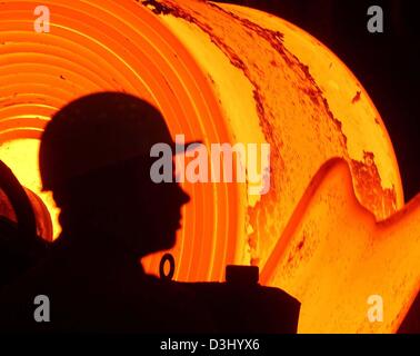 (Dpa-Dateien) - ist die Silhouette des ein Stahlarbeiter vor einem Redhot gesehen, über 1200 Grad Celsius heißen Stahl-Coils im ThyssenKrupp-Stahlwerk in Bochum, Deutschland, 12. Februar 2003. Am 23. Januar 2004 bestätigt ThyssenKrupp ihr Ziel, ein Bruttoergebnis von knapp 1 Milliarde Euro im laufenden Geschäftsjahr 2003/2004 zu erreichen. Das Unternehmen kündigte auch die Eckdaten für die Tannen Stockfoto