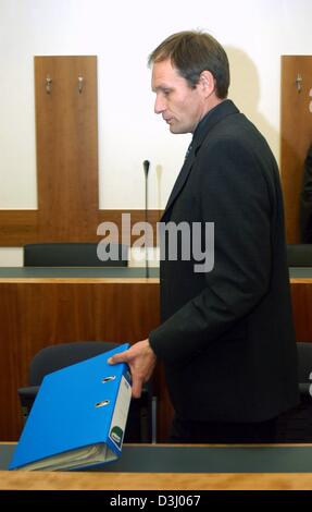 (Dpa) - mit einem Dateiordner in der Hand 42 Jahre alte deutsche Computer-Spezialist Armin Meiwes, der sogenannte "Kannibale von Rotenburg", kommt zu seinem Prozess vor dem Amtsgericht in Kassel, Deutschland auf Montag, 19. Januar 2004. Mordprozess von der selbsternannten Kannibale weiter am elften Tag. Zu Beginn der Studie Meiwes hat zugegeben, töten und Essen seine Opfer, sondern d Stockfoto