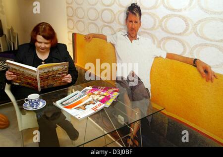 (Dpa) - Designerin Susanne Schmidt sitzt auf einem Stuhl in ihrer Wohnung und liest über einen Katalog in Mainz, Deutschland, 14. Januar 2004. Schmidt hat eine ungewöhnliche Idee, durch Druck lebensgroße Bilder von Menschen auf Tapete, die gemeint sind, die Schaffung eines günstigen Umfelds in Appartements für Singles. Schmidt und ihre Kollegin Andrea Baum wollen, bringen Sie ihre Tapete auf dem Markt in der Mitte des Stockfoto